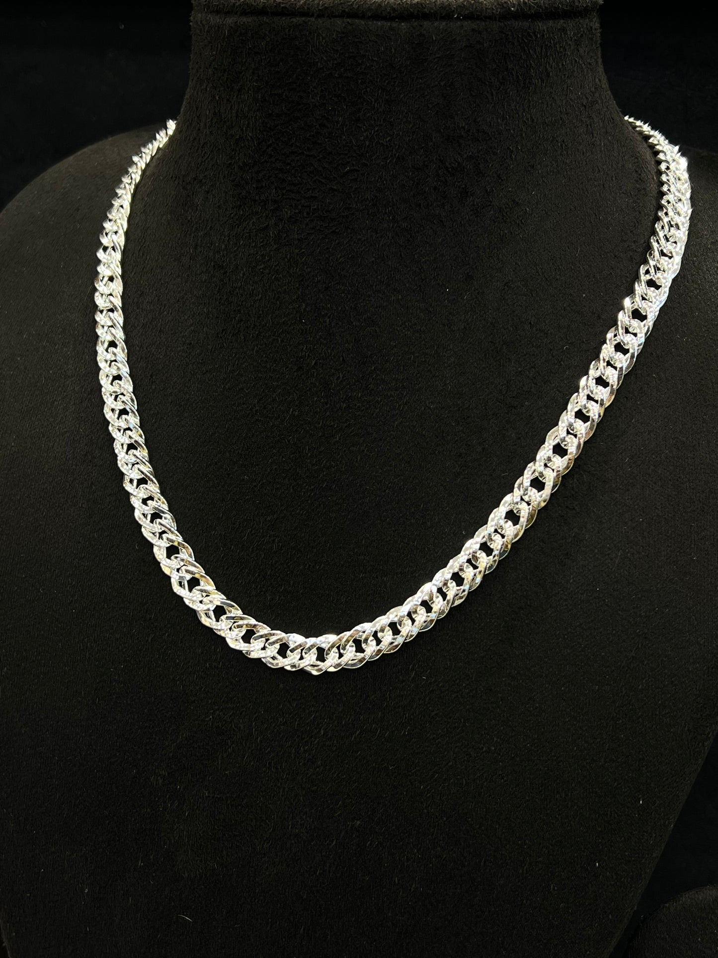 Silver chain necklace on a black mannequin