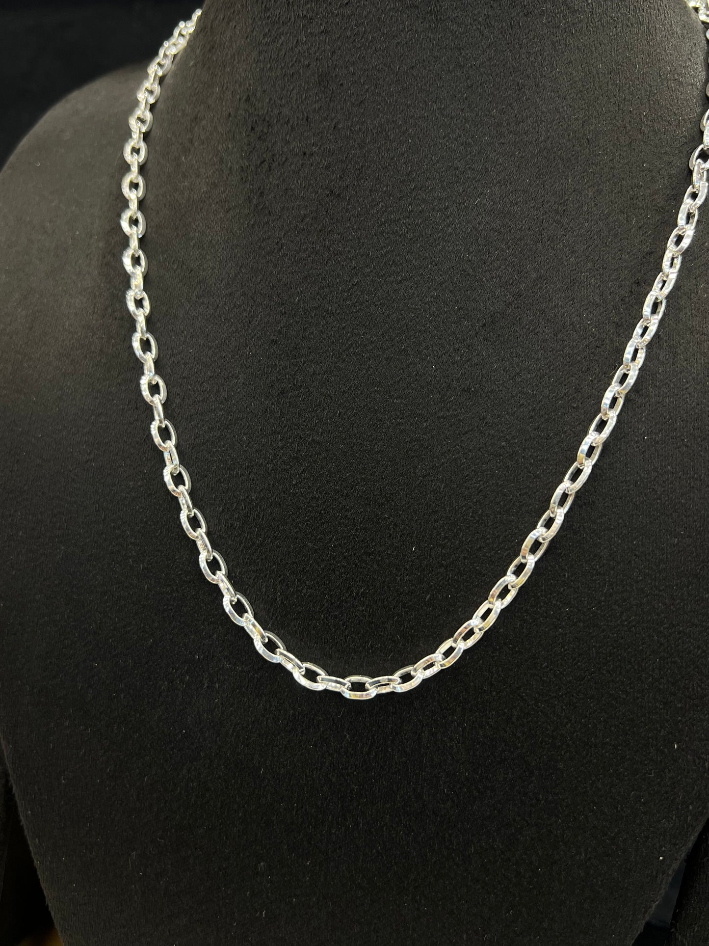Silver chain necklace on a black mannequin