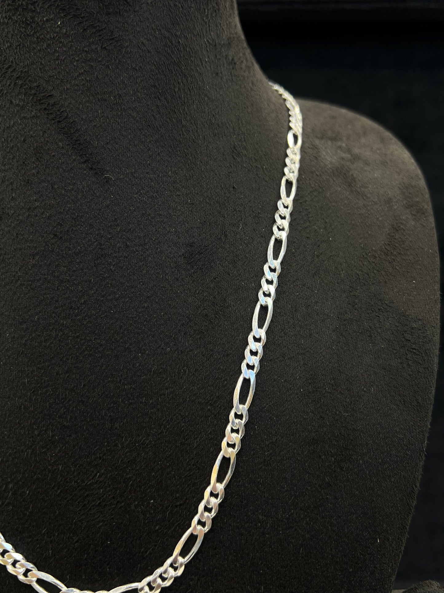 Silver chain necklace on a black mannequin bust