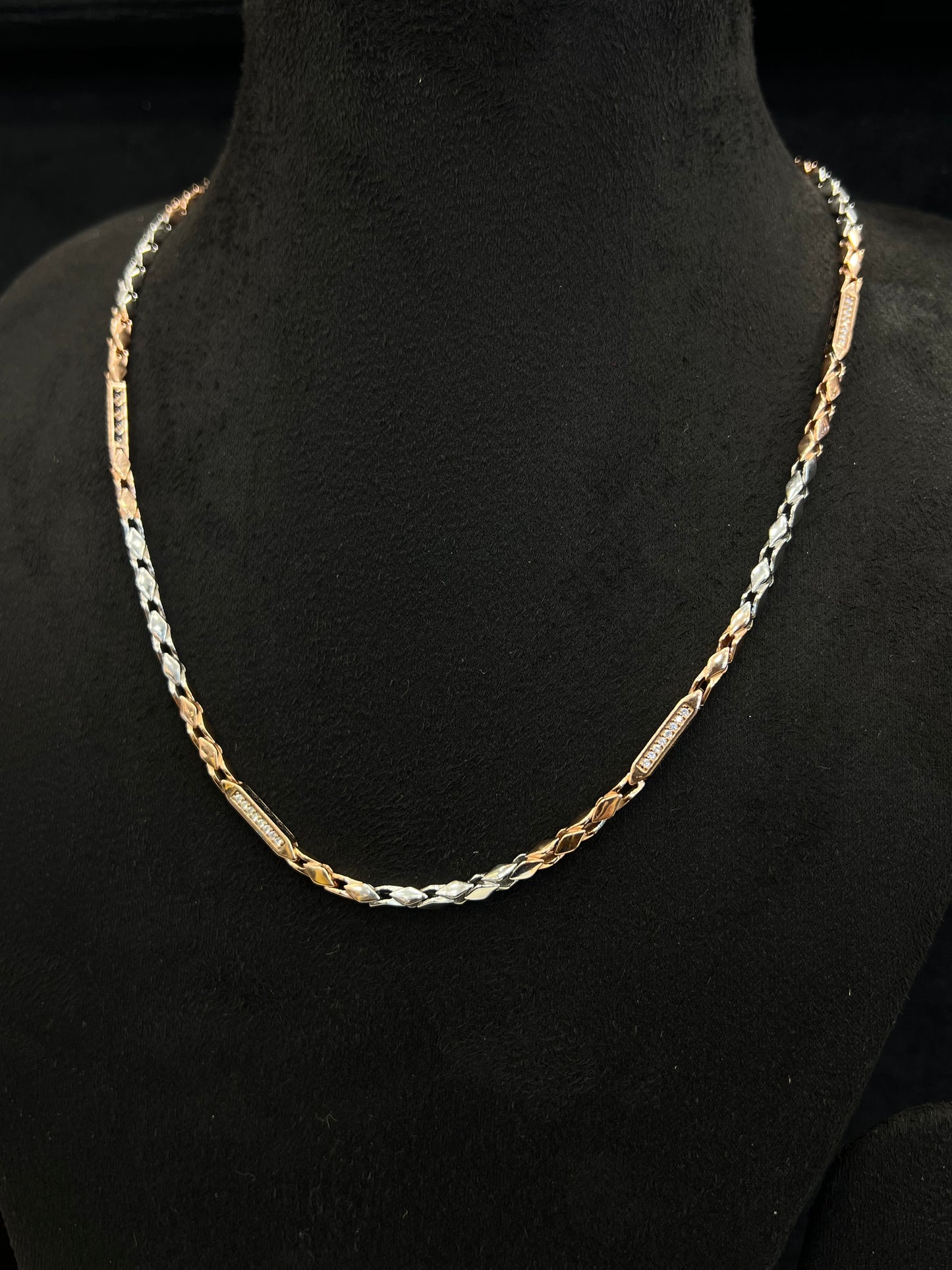 Gold and silver chain necklace on a black mannequin