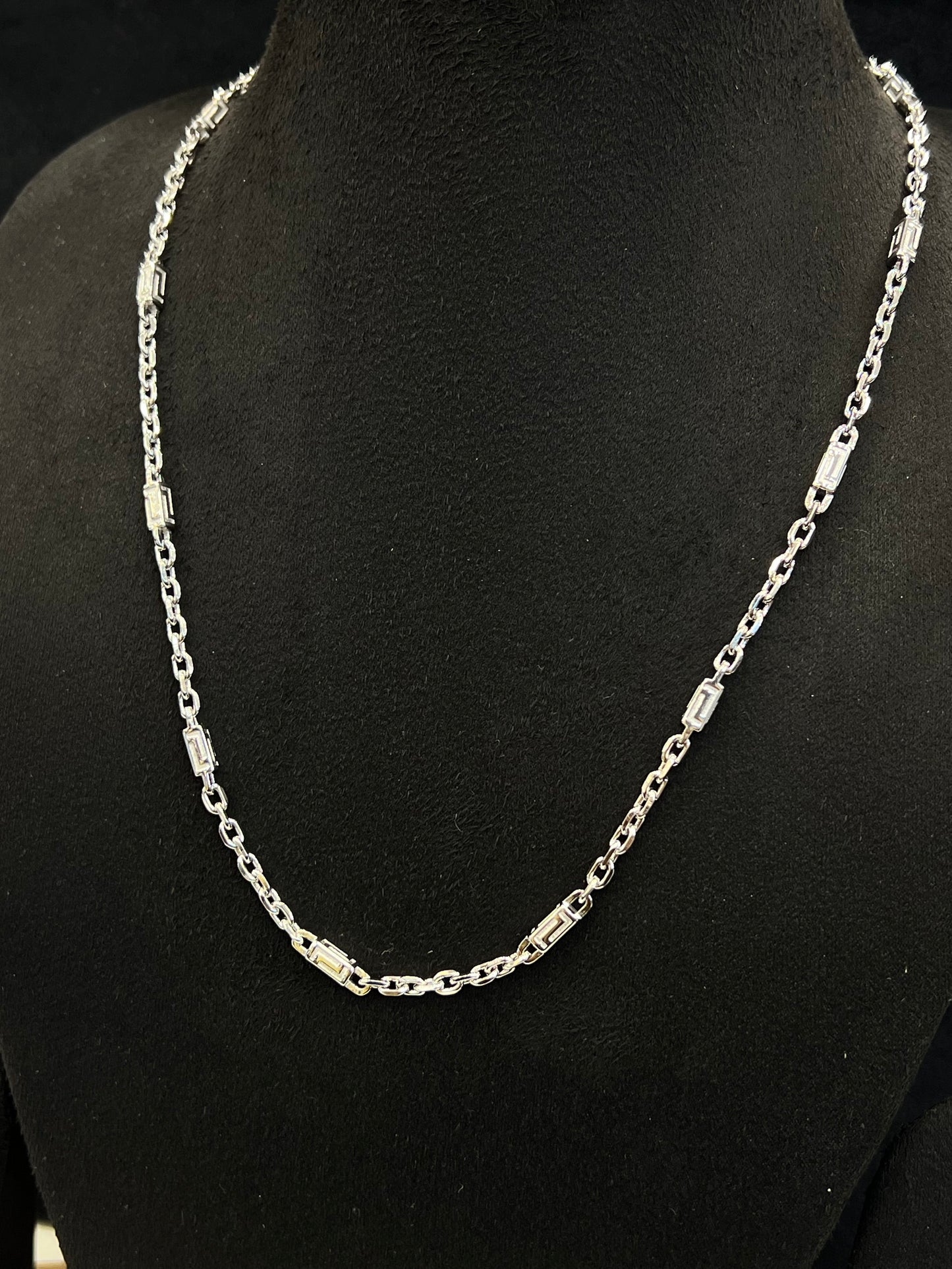 Silver chain necklace on a black mannequin