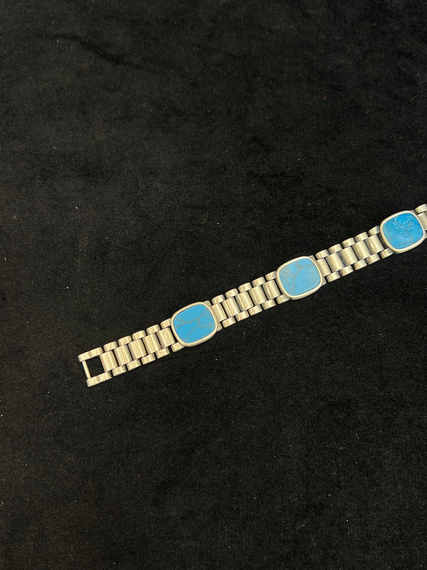 Bracelet with blue square stones on a black background