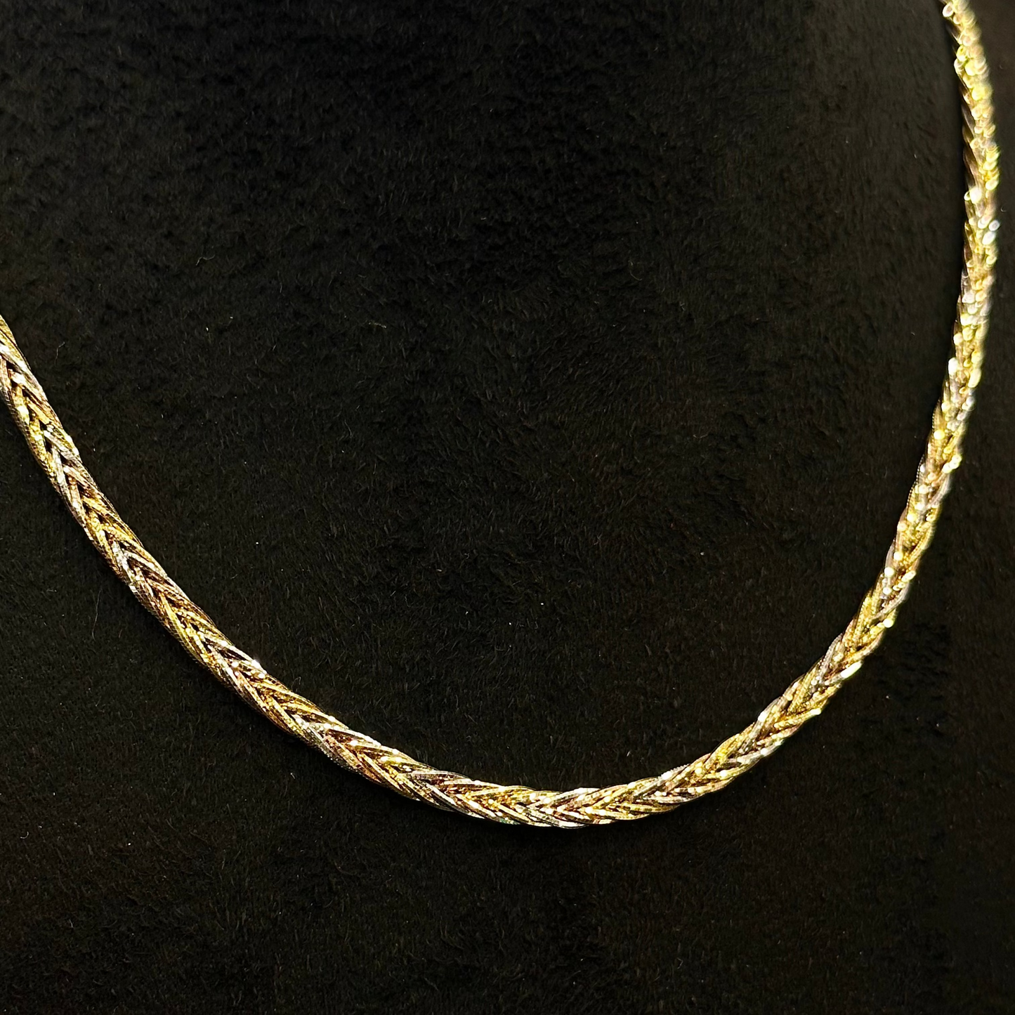 Gold chain necklace on a black background