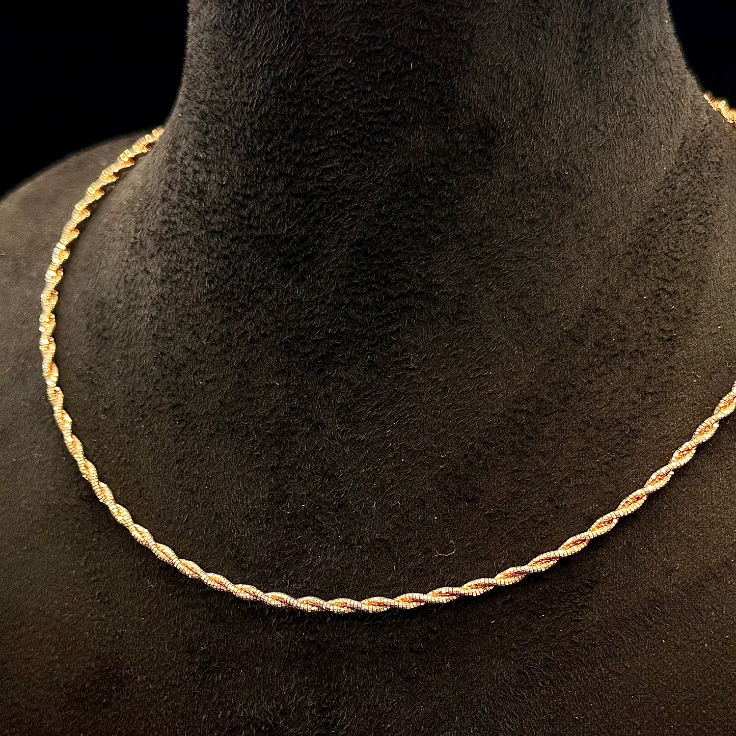 Gold rope chain necklace on a black mannequin bust