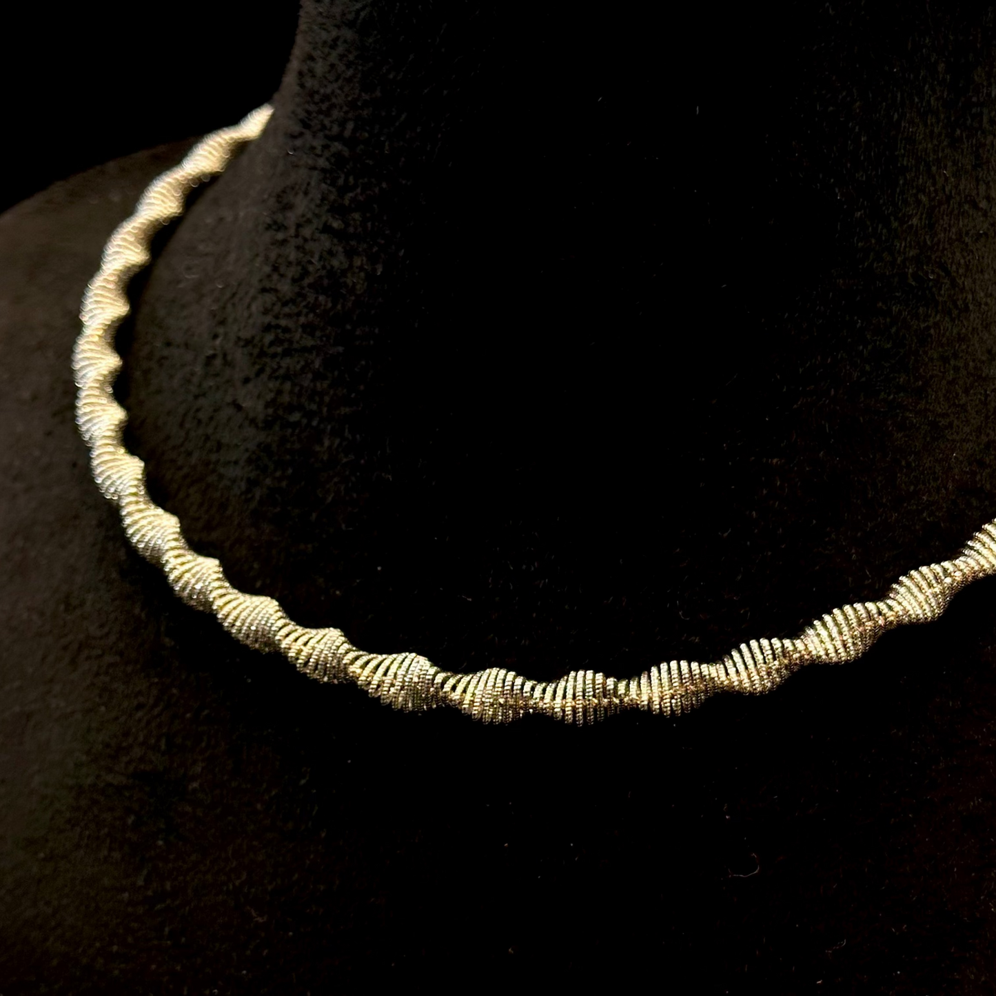 Silver necklace on a black mannequin bust