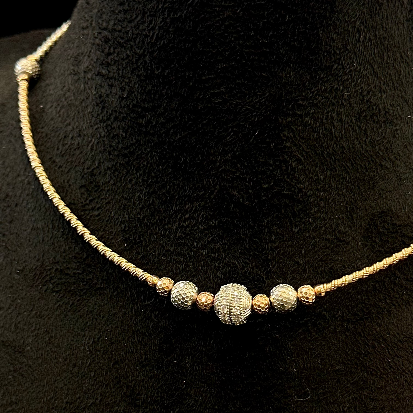 Necklace with textured beads on a black mannequin