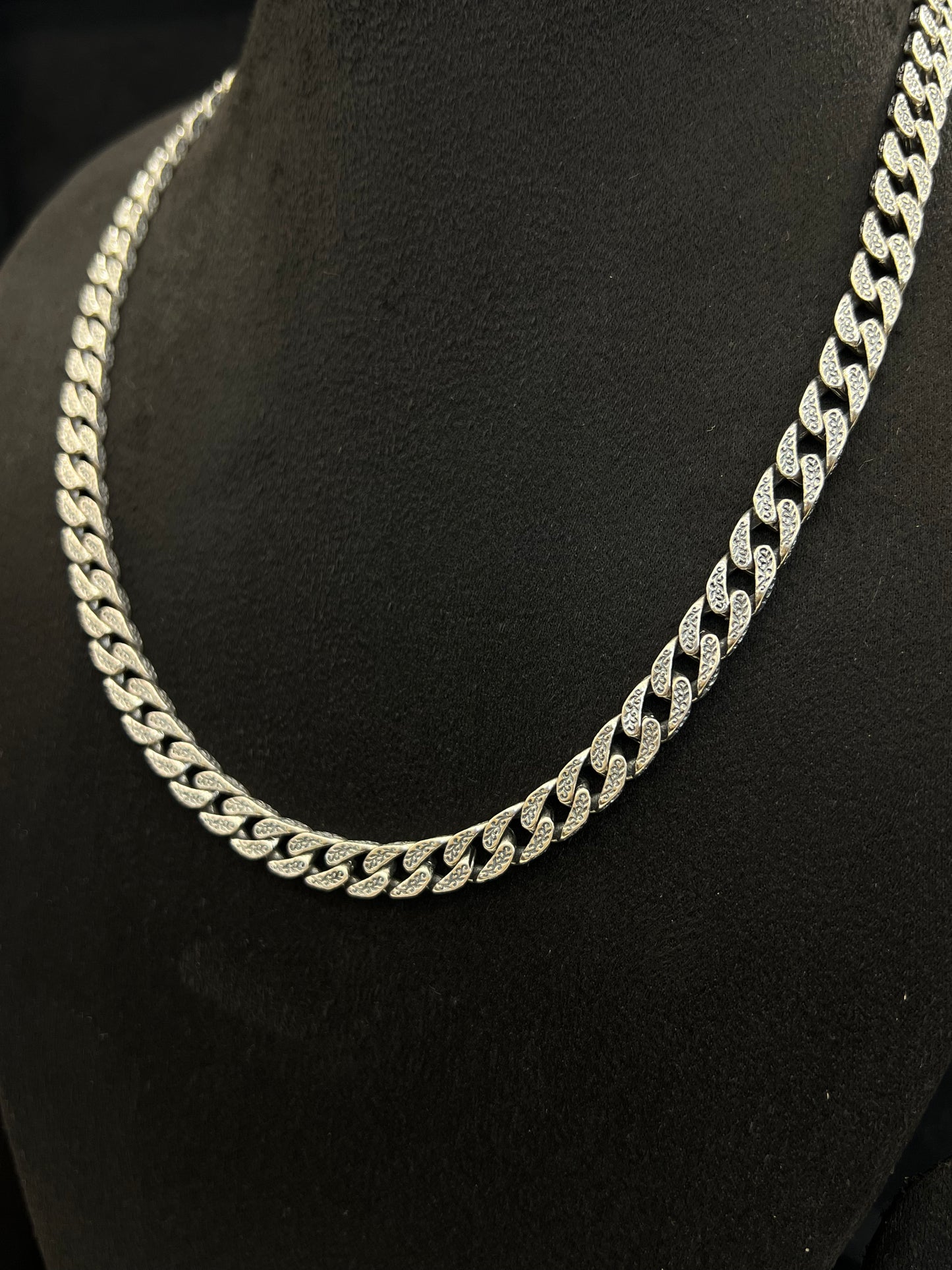 Silver chain necklace on a black mannequin bust