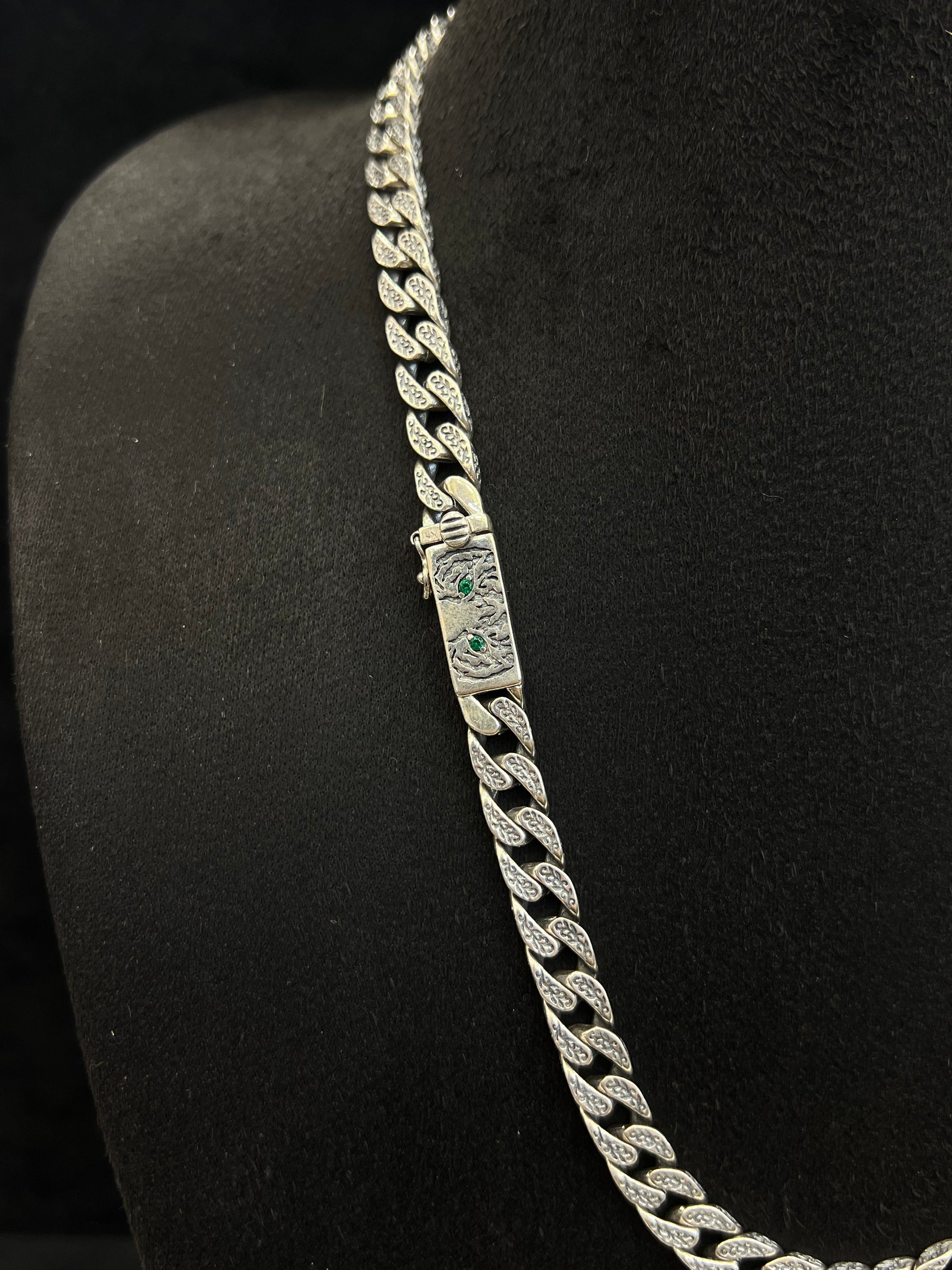 Silver chain necklace on a black stand