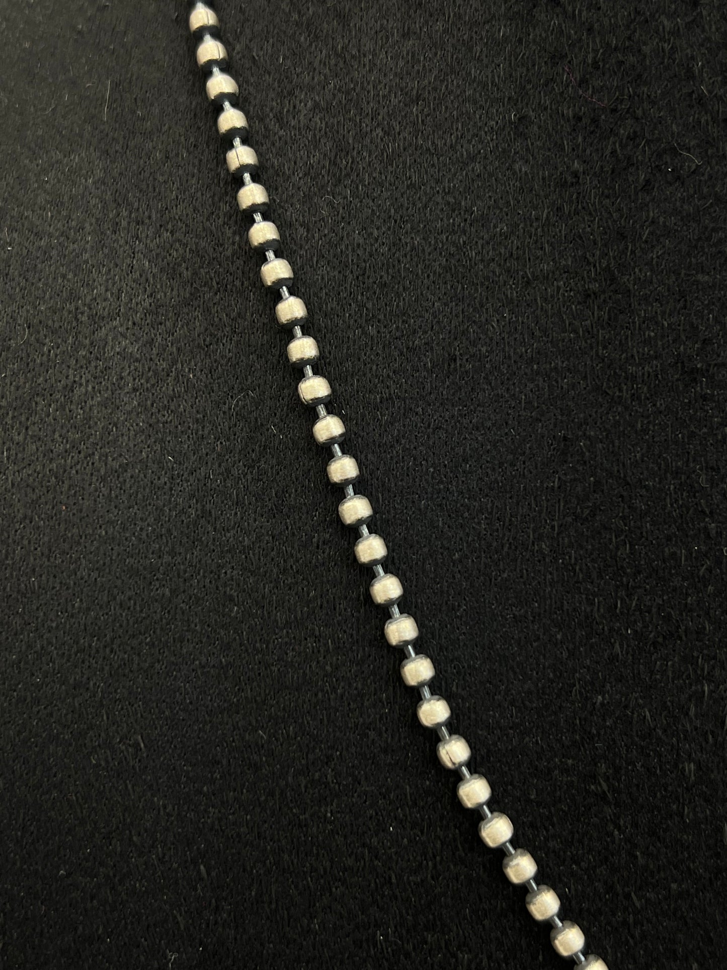 Close-up of a necklace with black and white beads on a black background