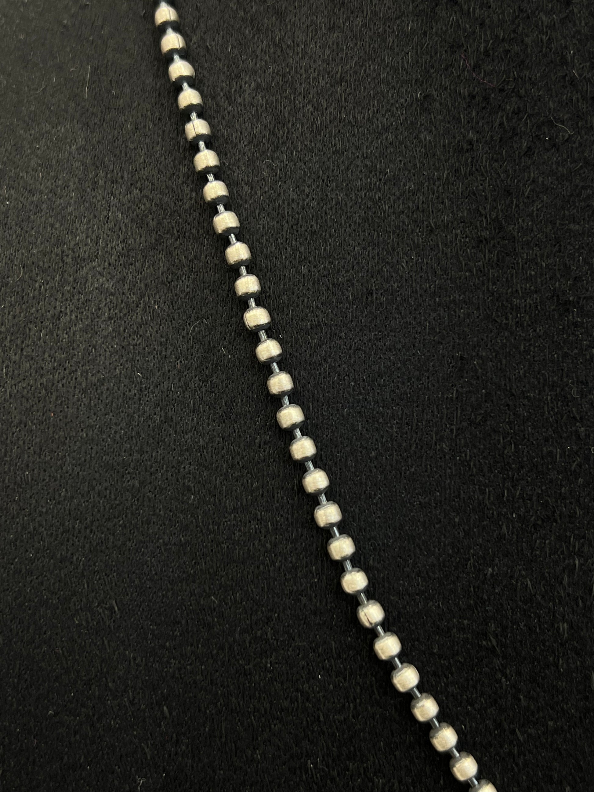 Close-up of a necklace with black and white beads on a black background