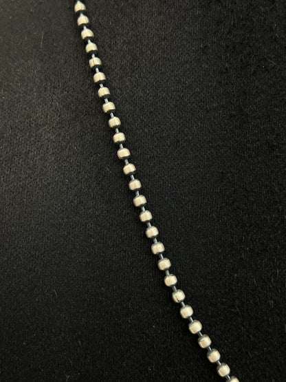 Close-up of a necklace with black and white beads on a black background