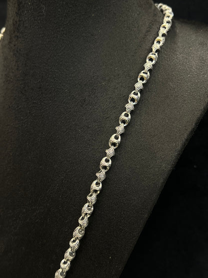 Silver chain necklace on a black mannequin