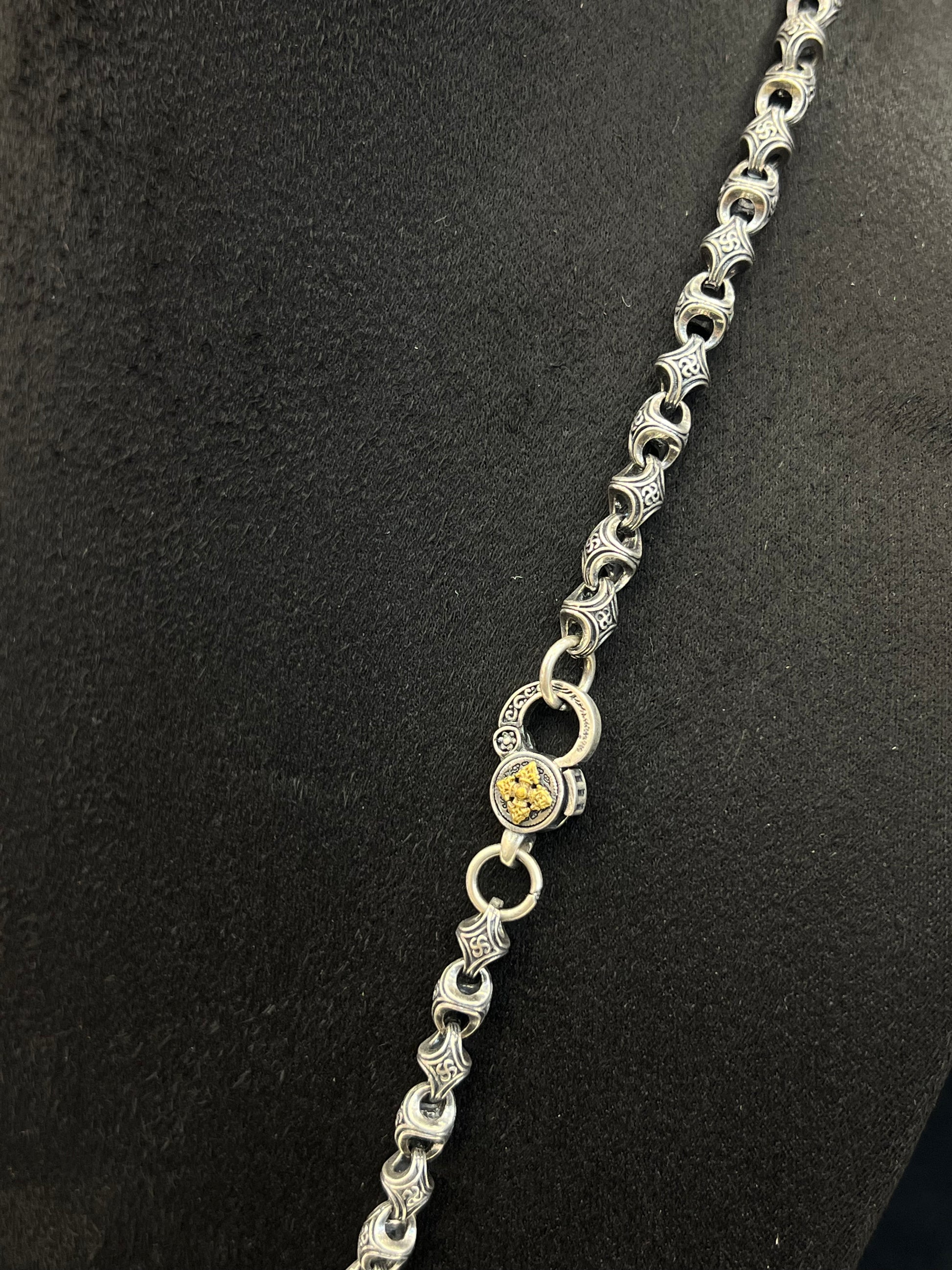 Silver chain necklace on a black background