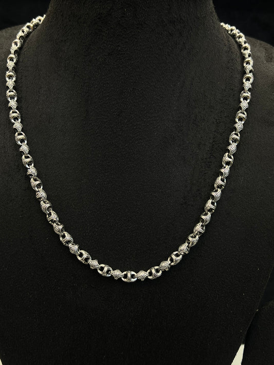 Silver chain necklace on a black mannequin