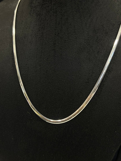 Silver snake chain necklace on a black background