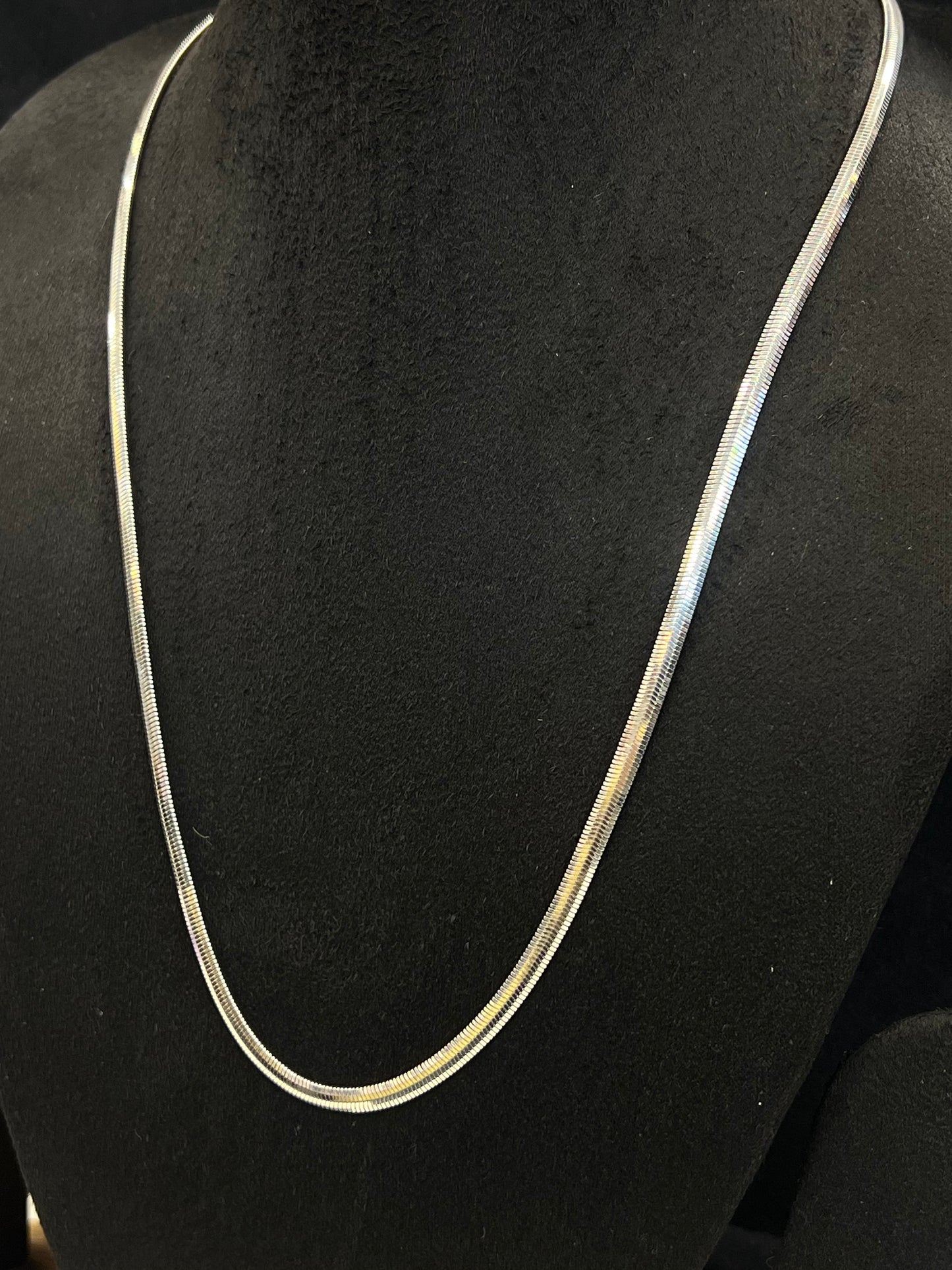 Silver necklace on a black mannequin