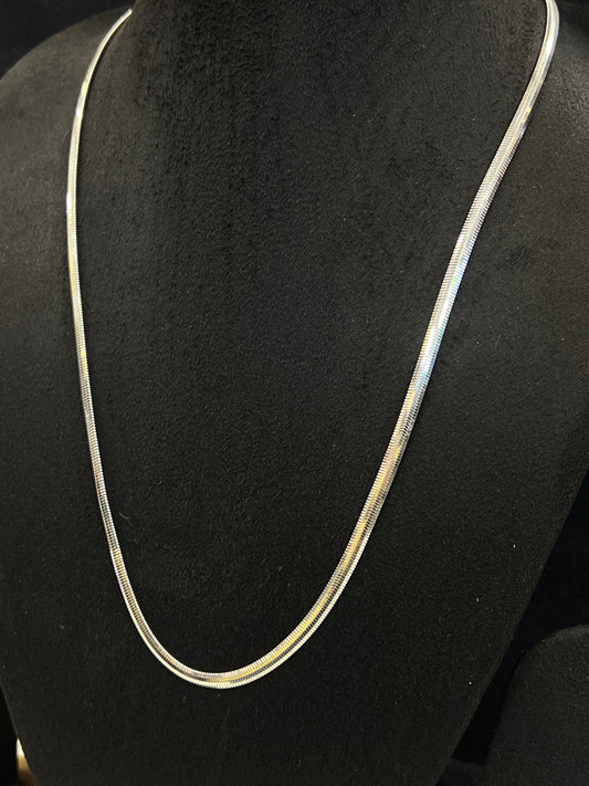 Silver necklace on a black mannequin