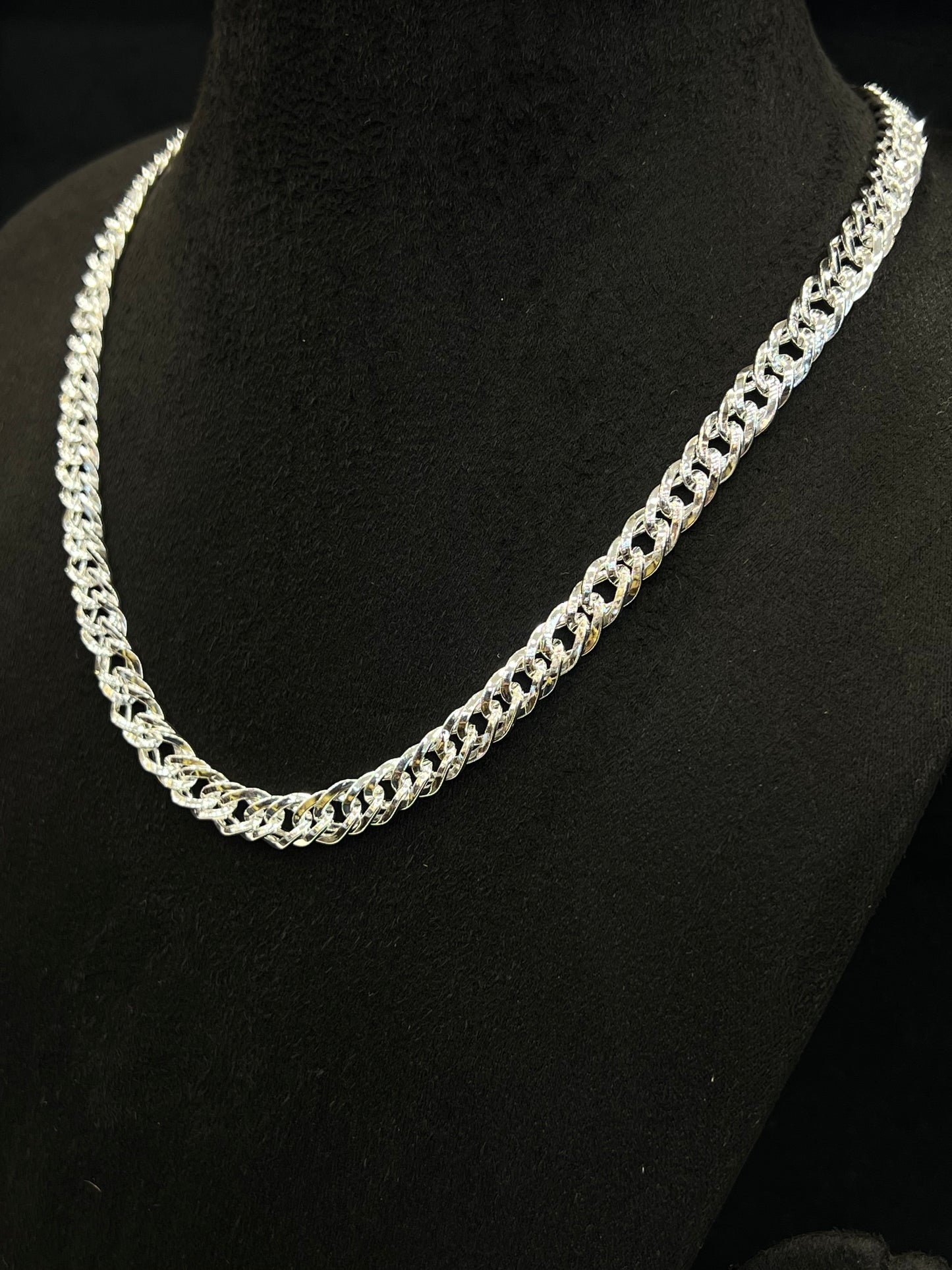 Silver chain necklace on a black mannequin