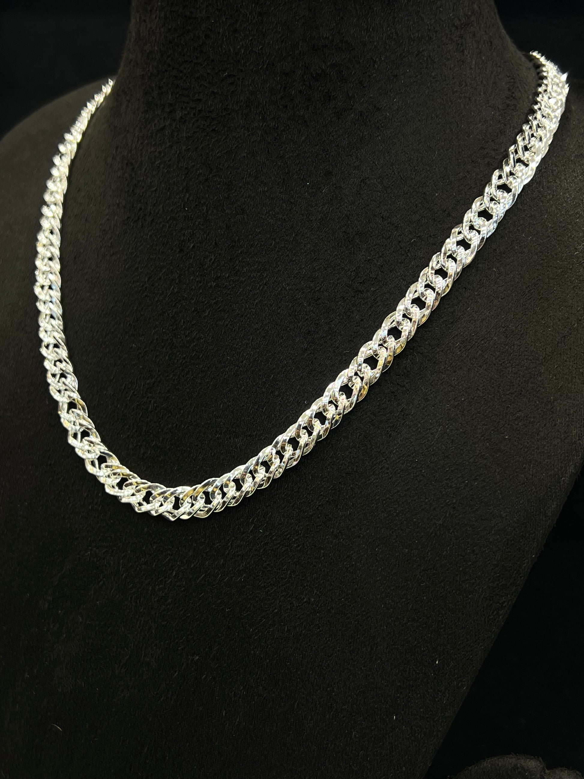Silver chain necklace on a black mannequin