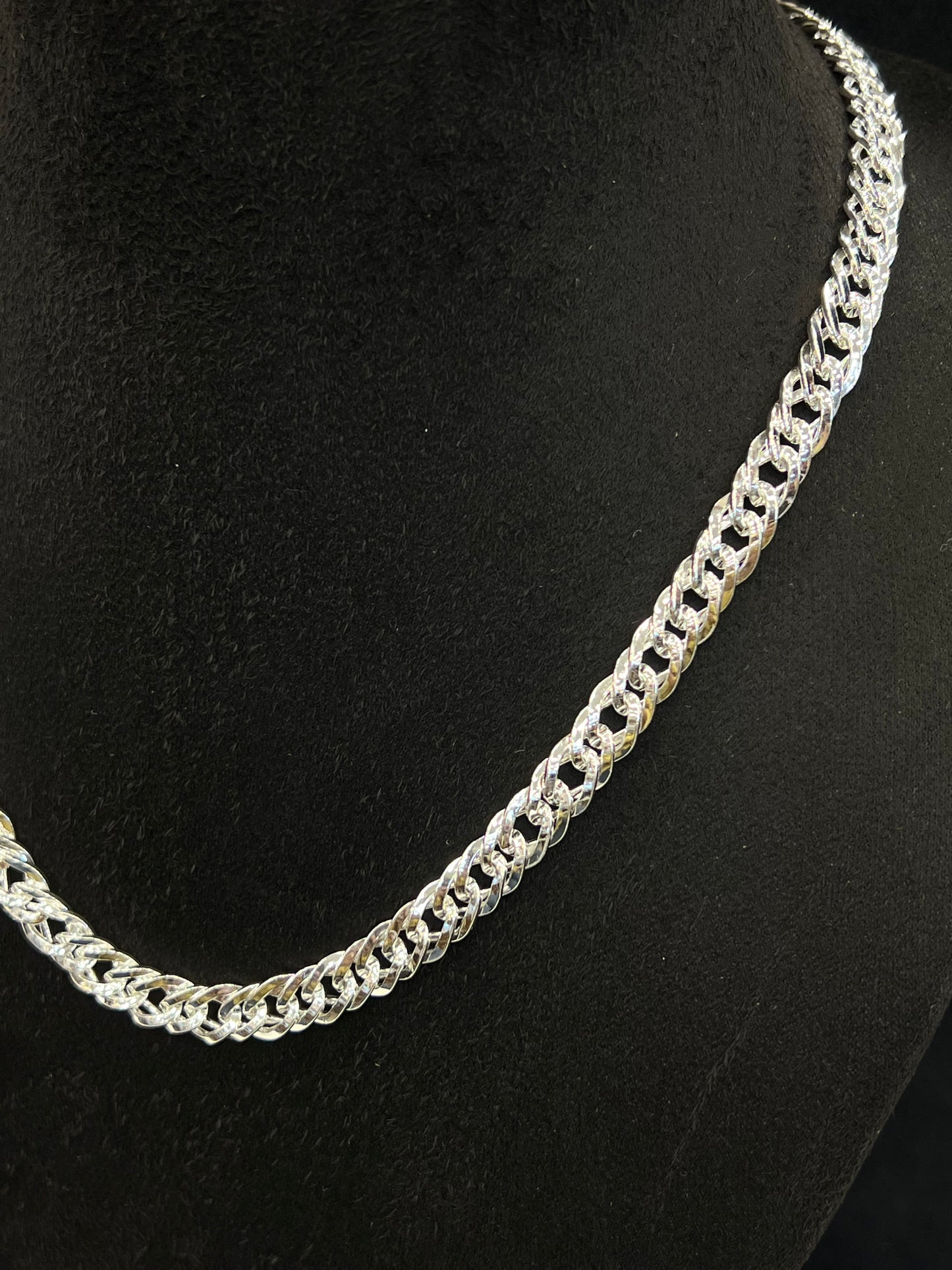 Silver chain necklace on a black background