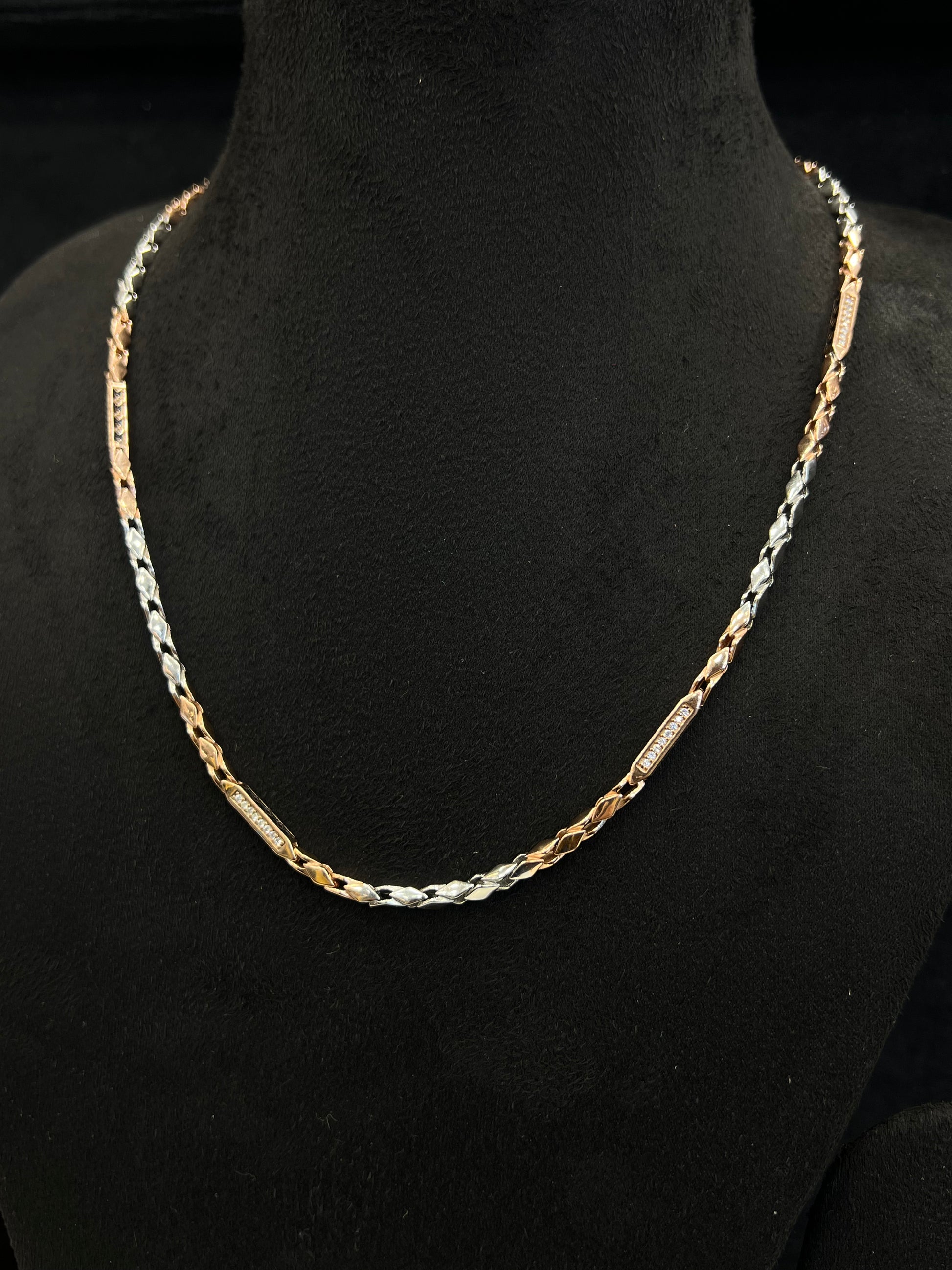 Gold and silver chain necklace on a black mannequin