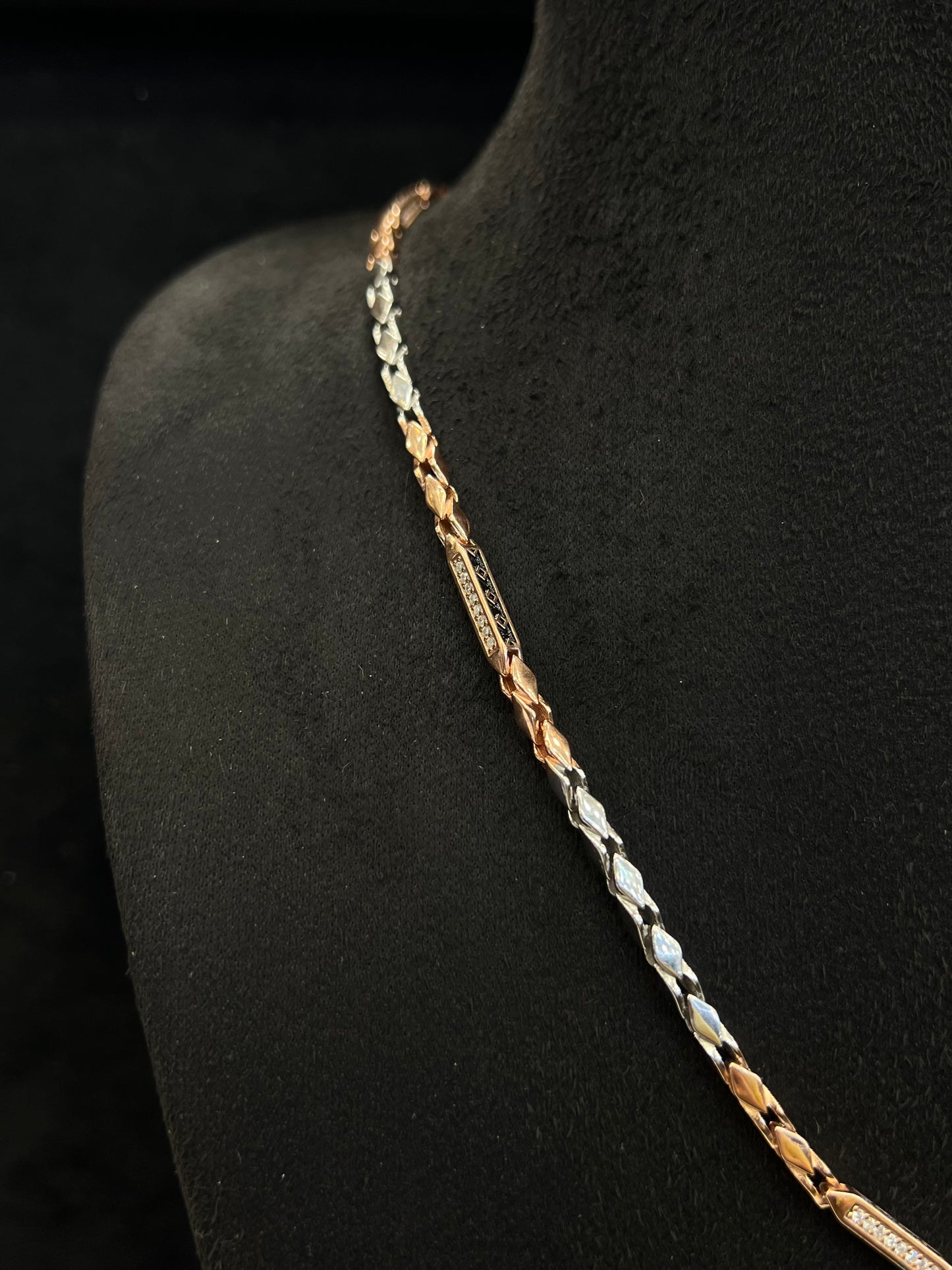 Three-colored chain necklace on a black mannequin.