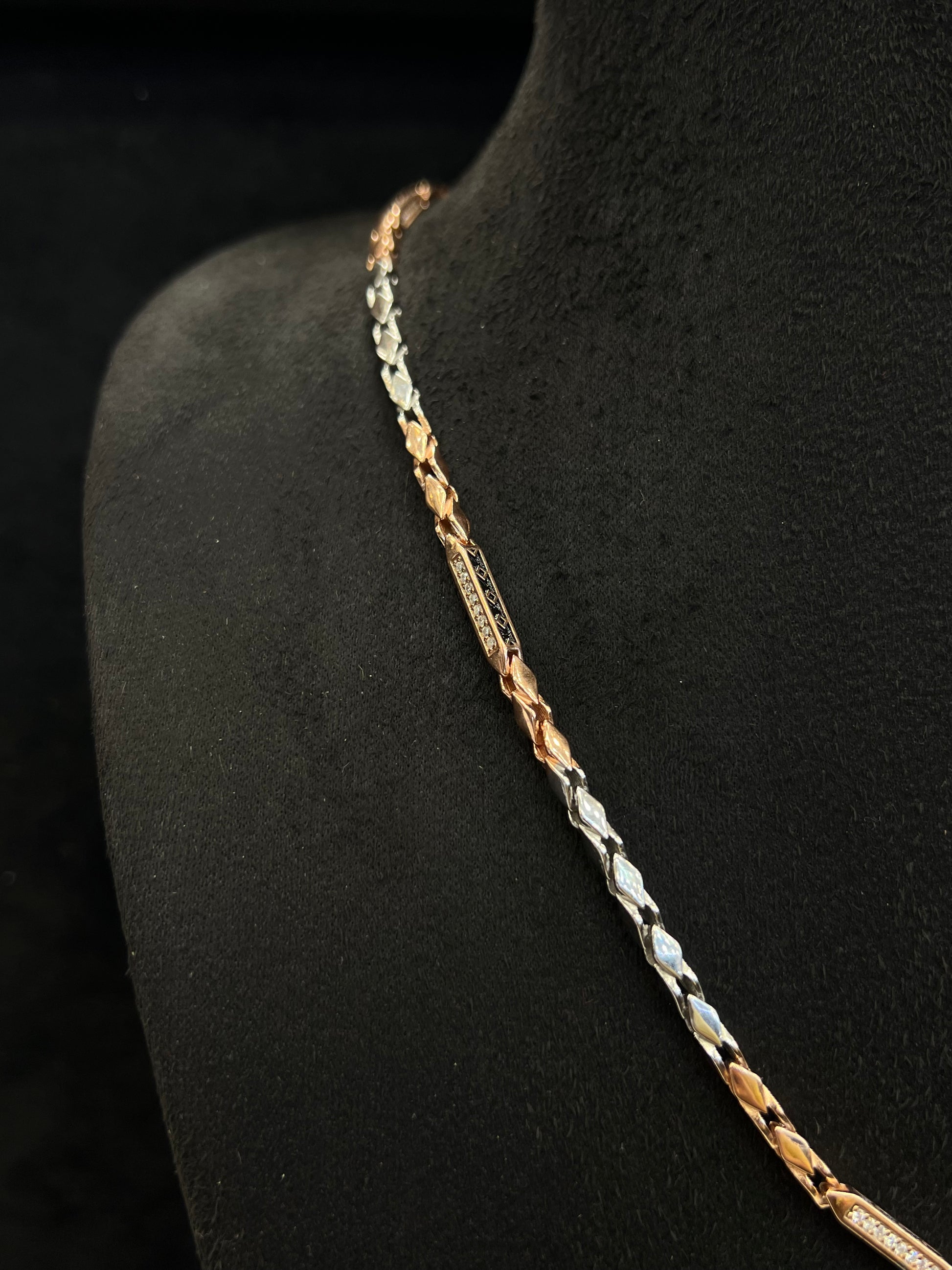 Three-colored chain necklace on a black mannequin.