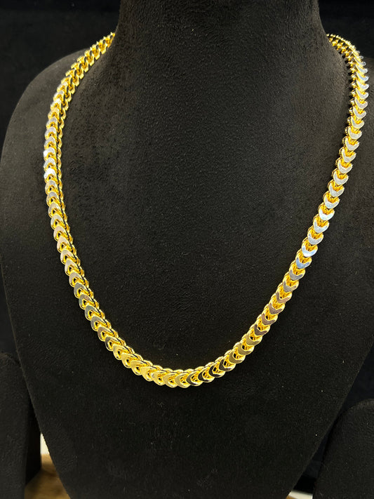 Gold chain necklace on a black mannequin