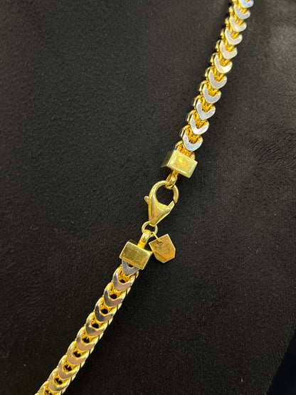 Gold chain necklace with a clasp on a black background