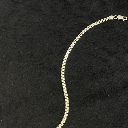Gold chain bracelet on a black background