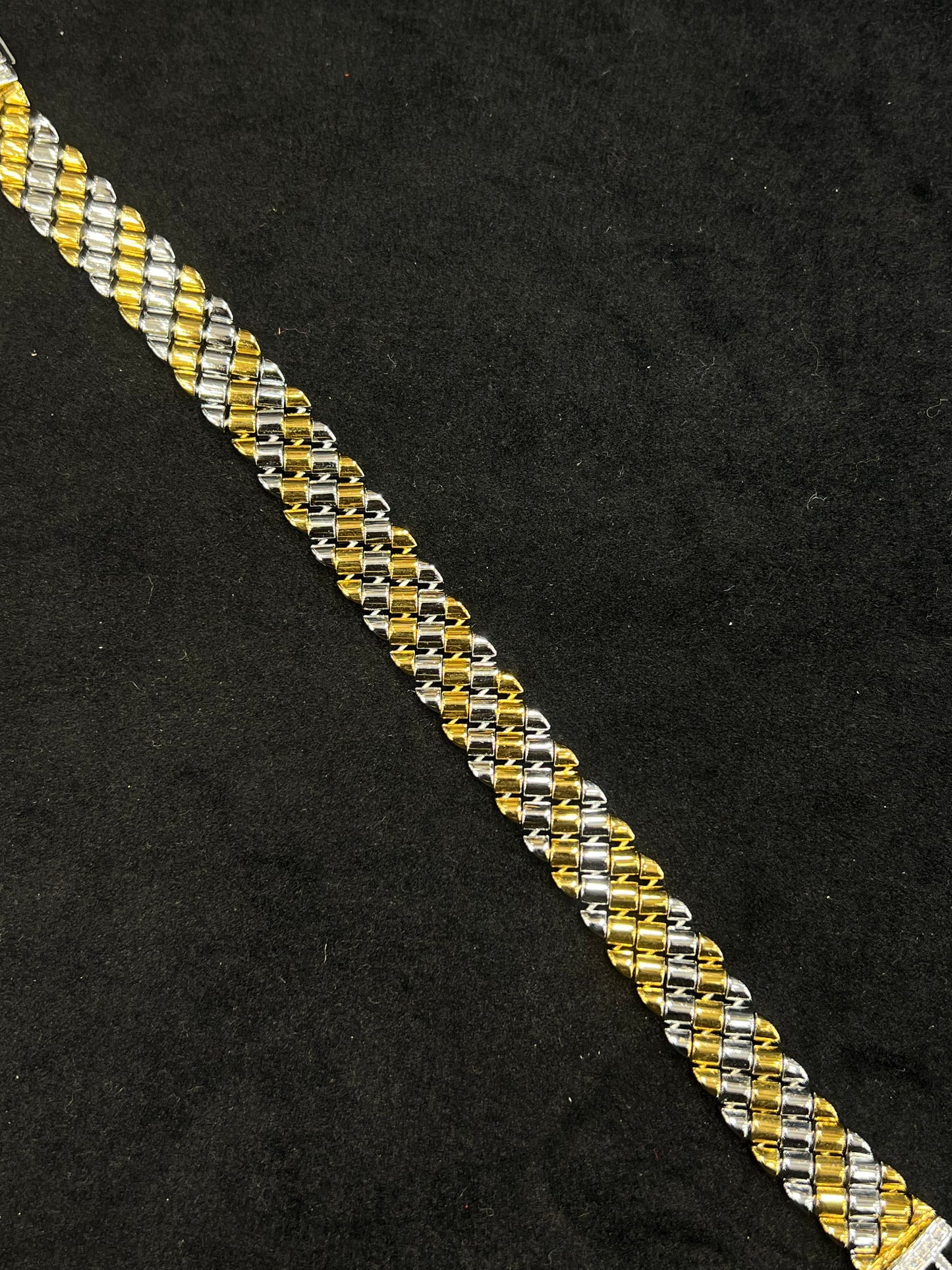 Two-tone gold and silver bracelet on a black background