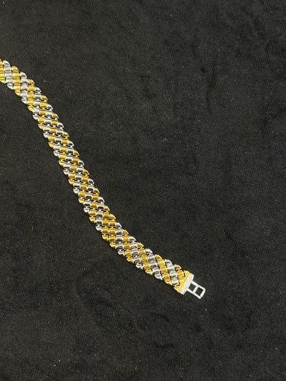 Two-tone gold and silver bracelet on a black background