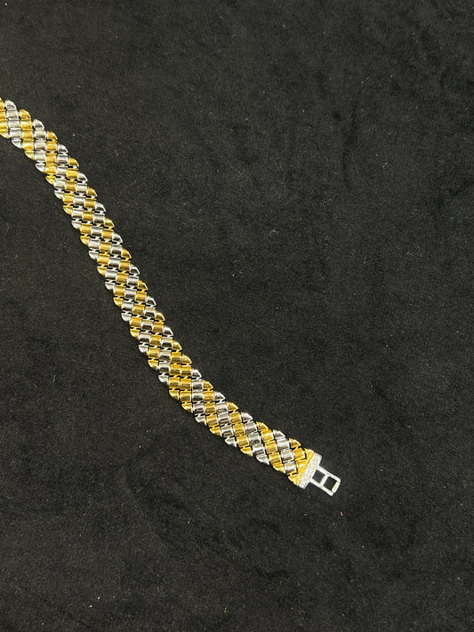 Two-tone gold and silver bracelet on a black background