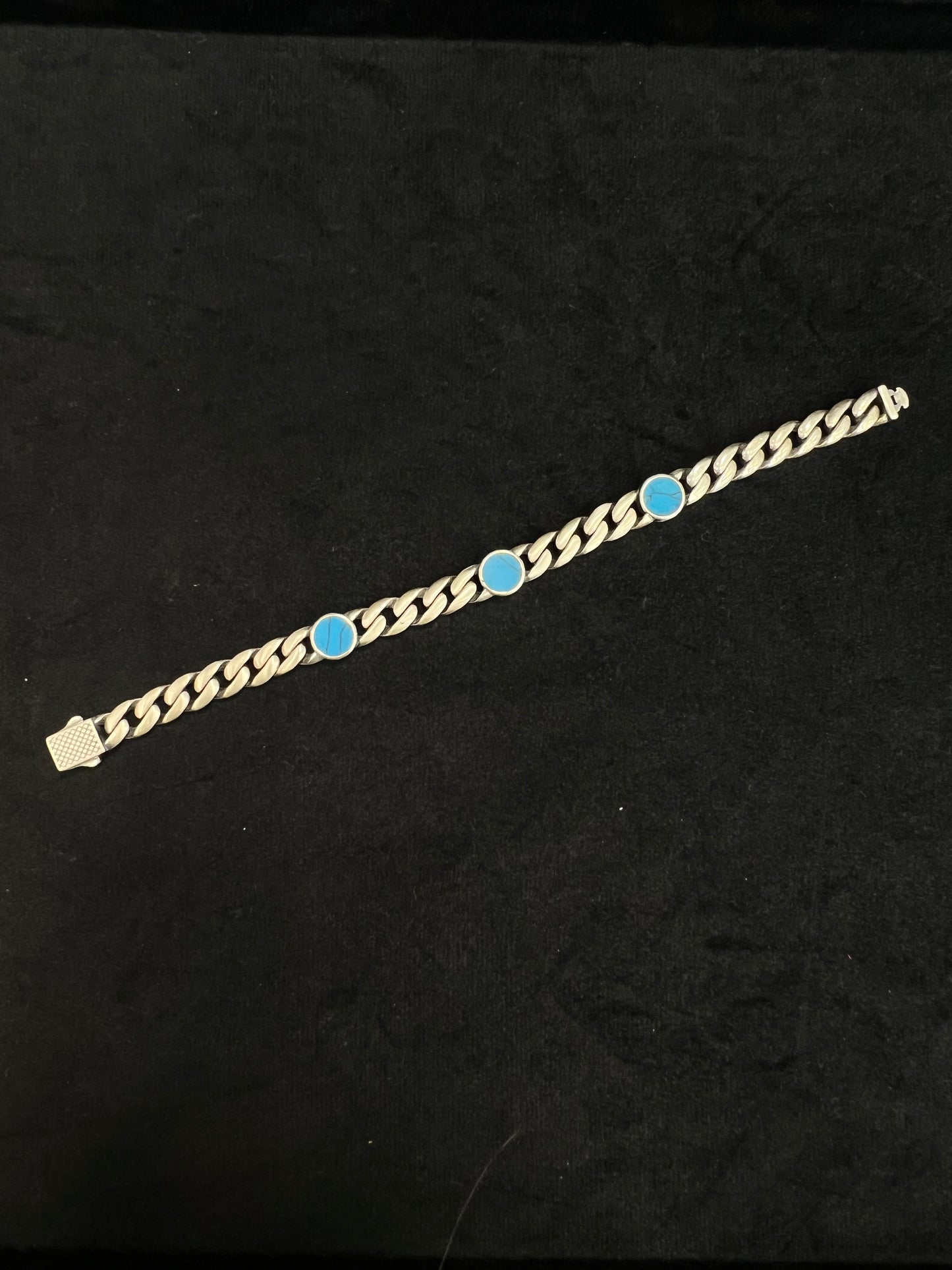 Gold bracelet with blue stones on a black background