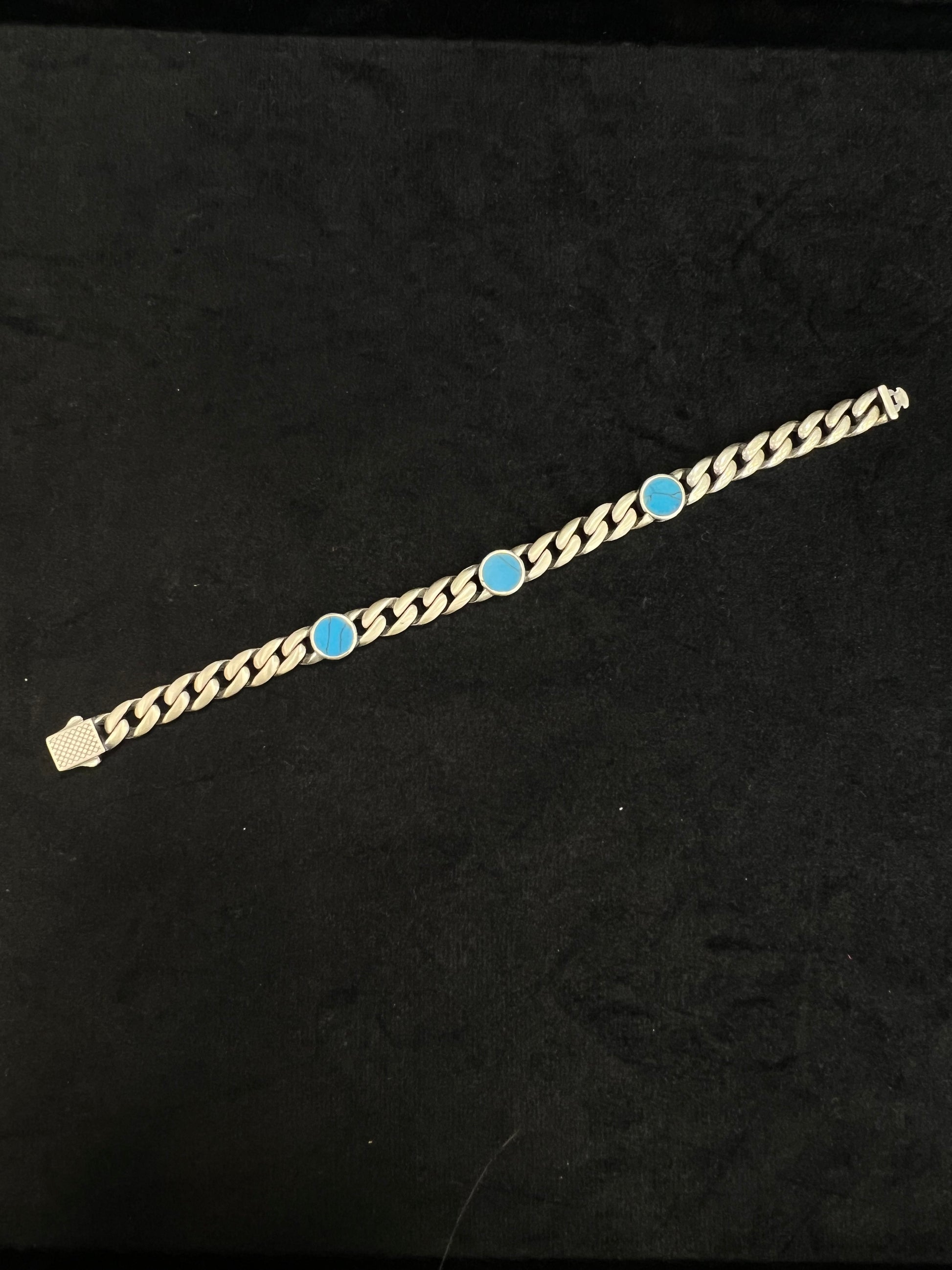 Gold bracelet with blue stones on a black background