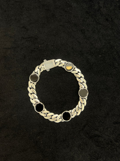 Silver bracelet with circular links on a black background