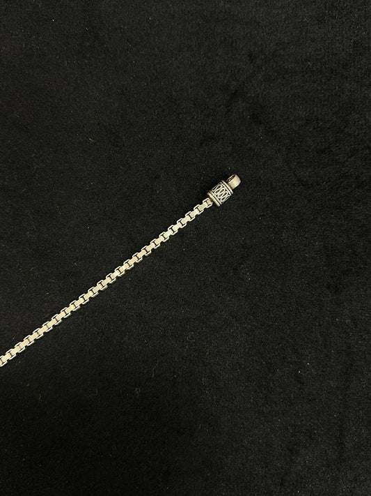 Gold chain bracelet on a black background