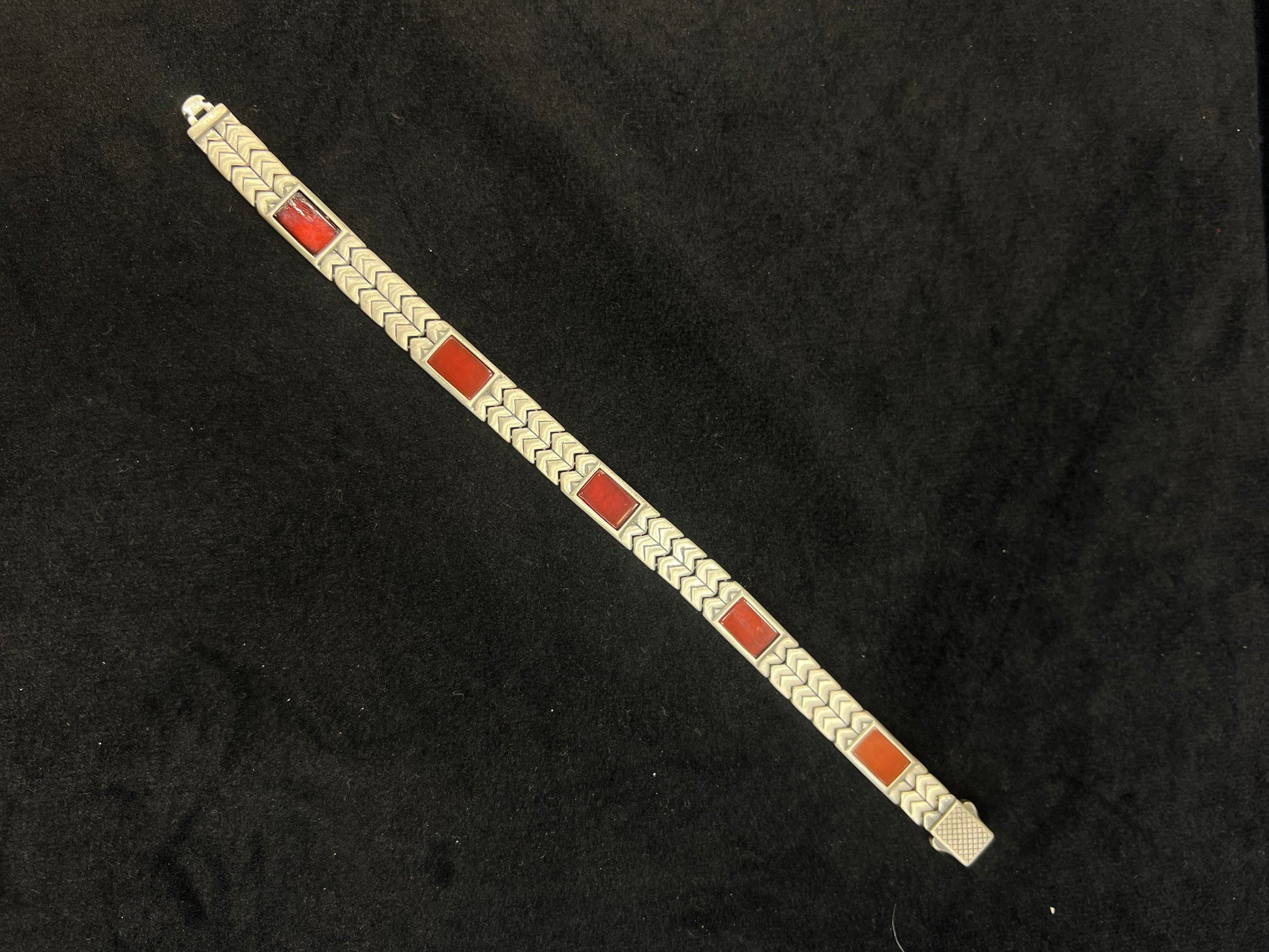 Bracelet with red and gold square pattern on a black background