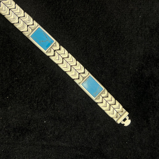Silver bracelet with blue stones on a black background