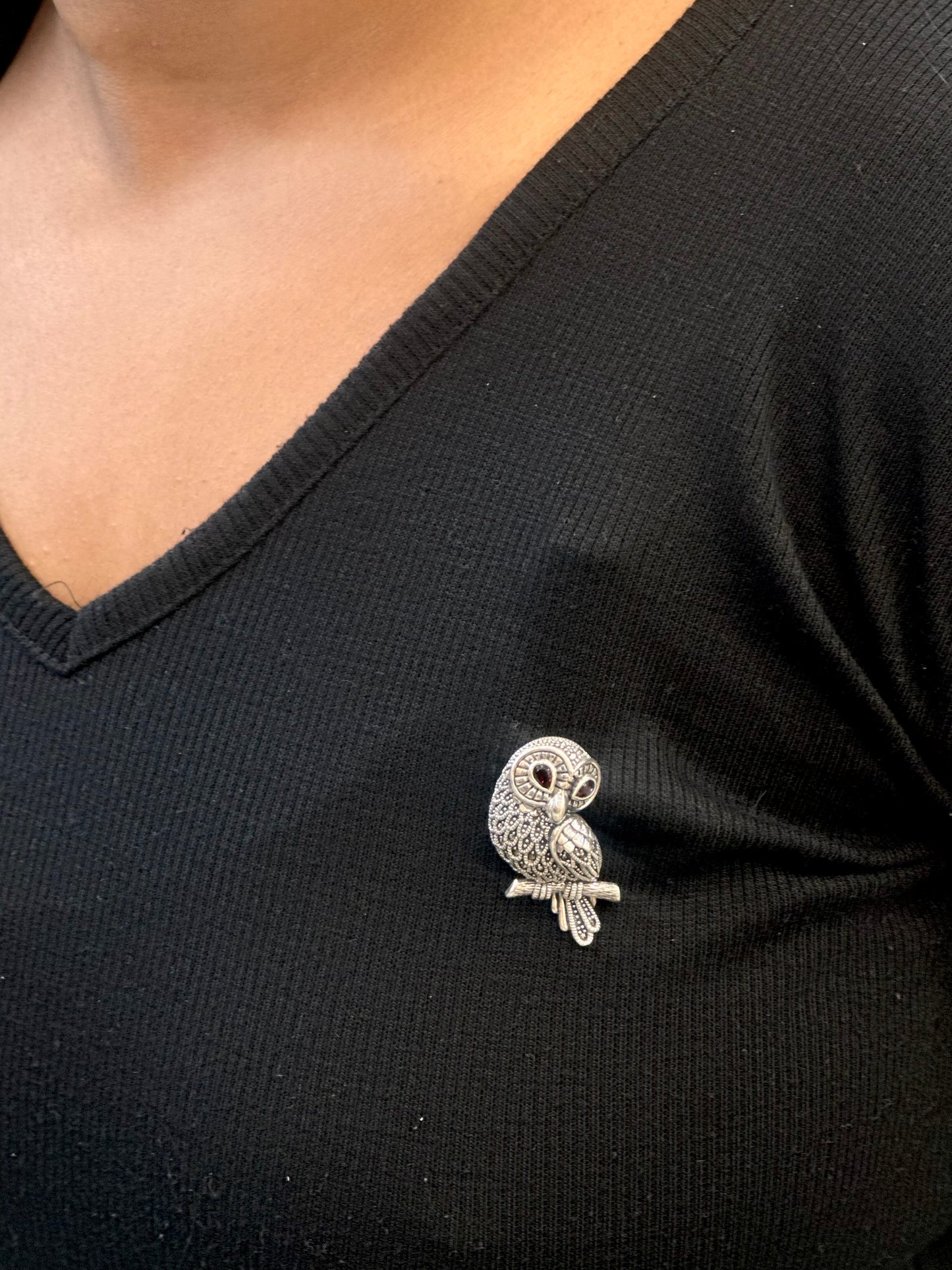 Silver owl brooch on a black shirt