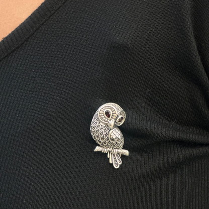 Silver owl brooch on a black shirt