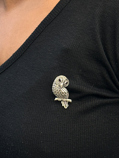 Gold owl brooch on a black garment