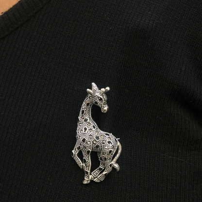 Silver giraffe brooch on a black garment