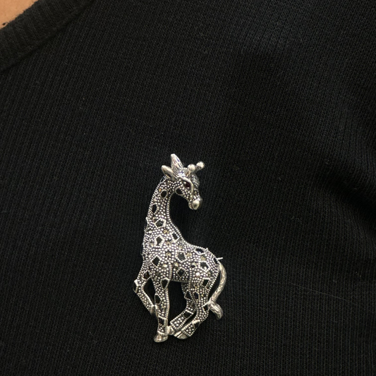Silver giraffe brooch on a black garment