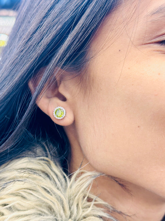 Close-up of a person wearing a green gemstone earring.