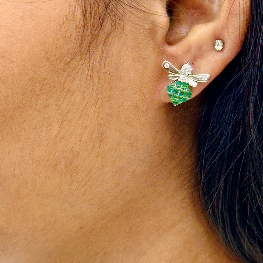 Close-up of an ear wearing a green and silver earring.