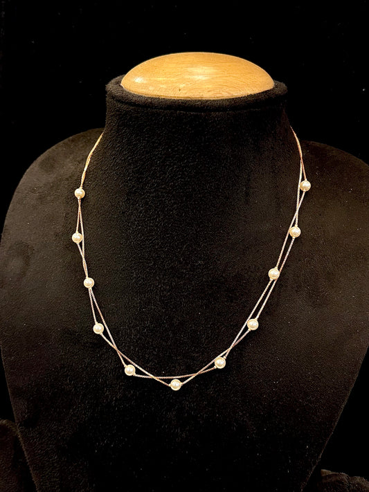 Necklace on a black mannequin bust with a wooden top