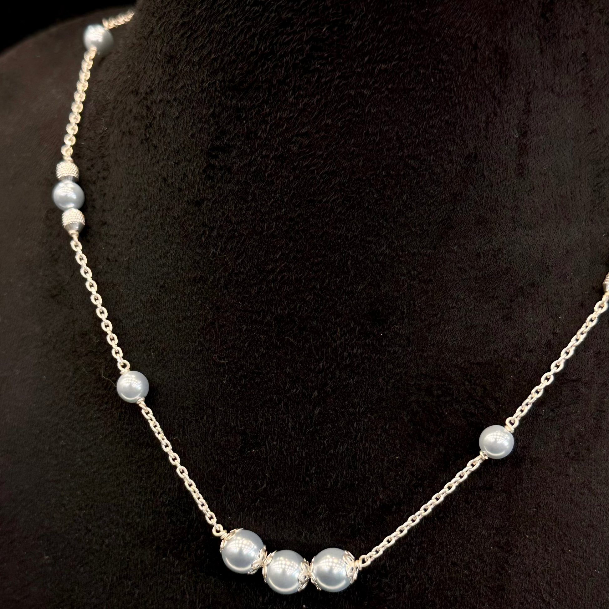 Pearl necklace on a black mannequin bust