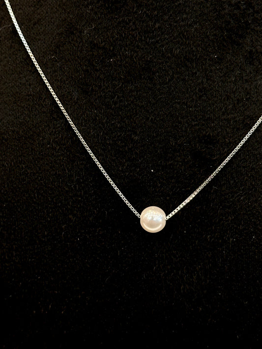 Necklace with a single pearl pendant on a black background