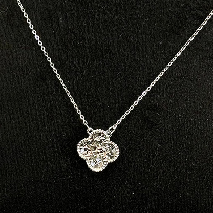 Silver necklace with a floral pendant on a black background